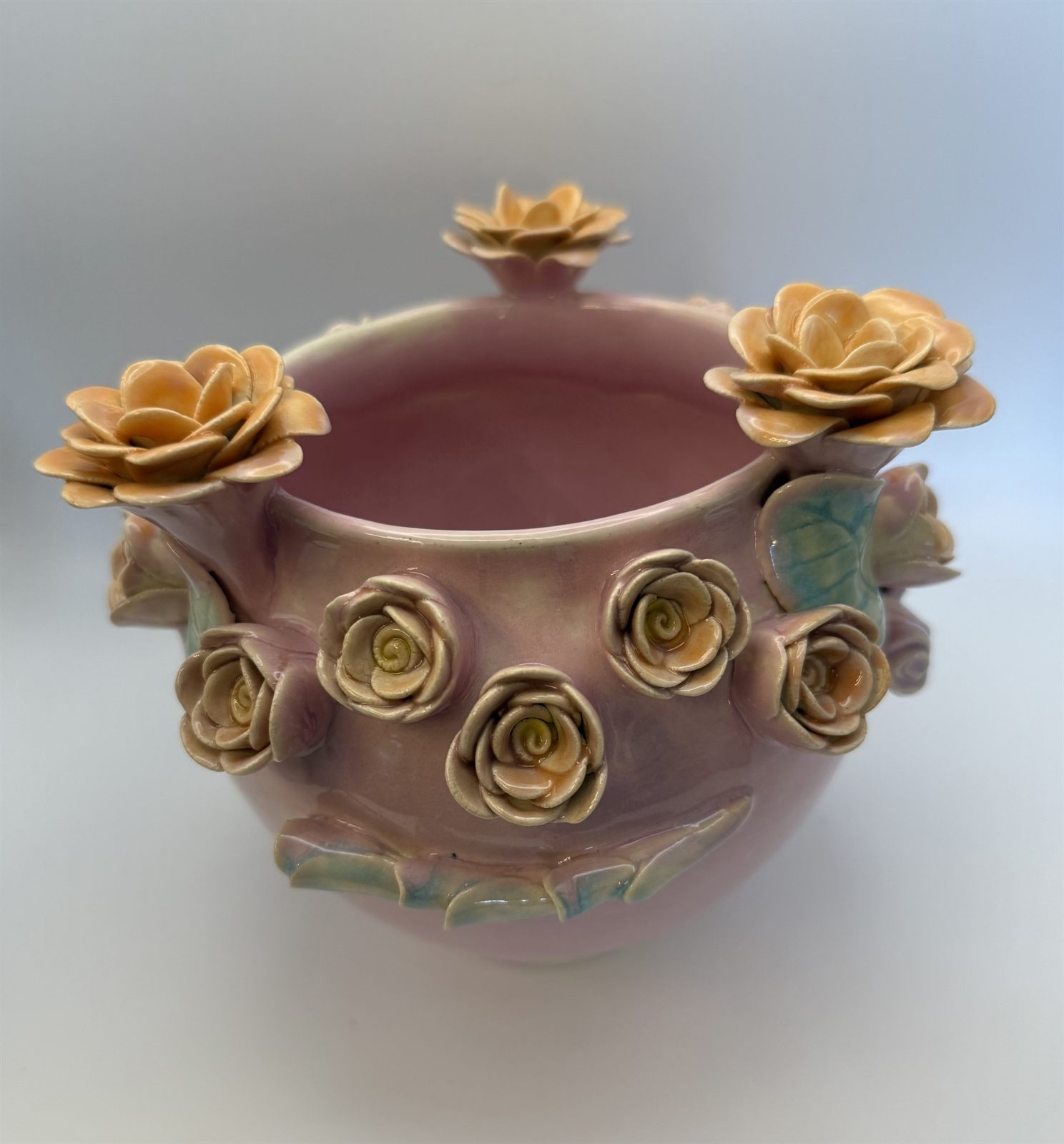 Pink-lavender pot with apricot blossoms rising on sculpted stems