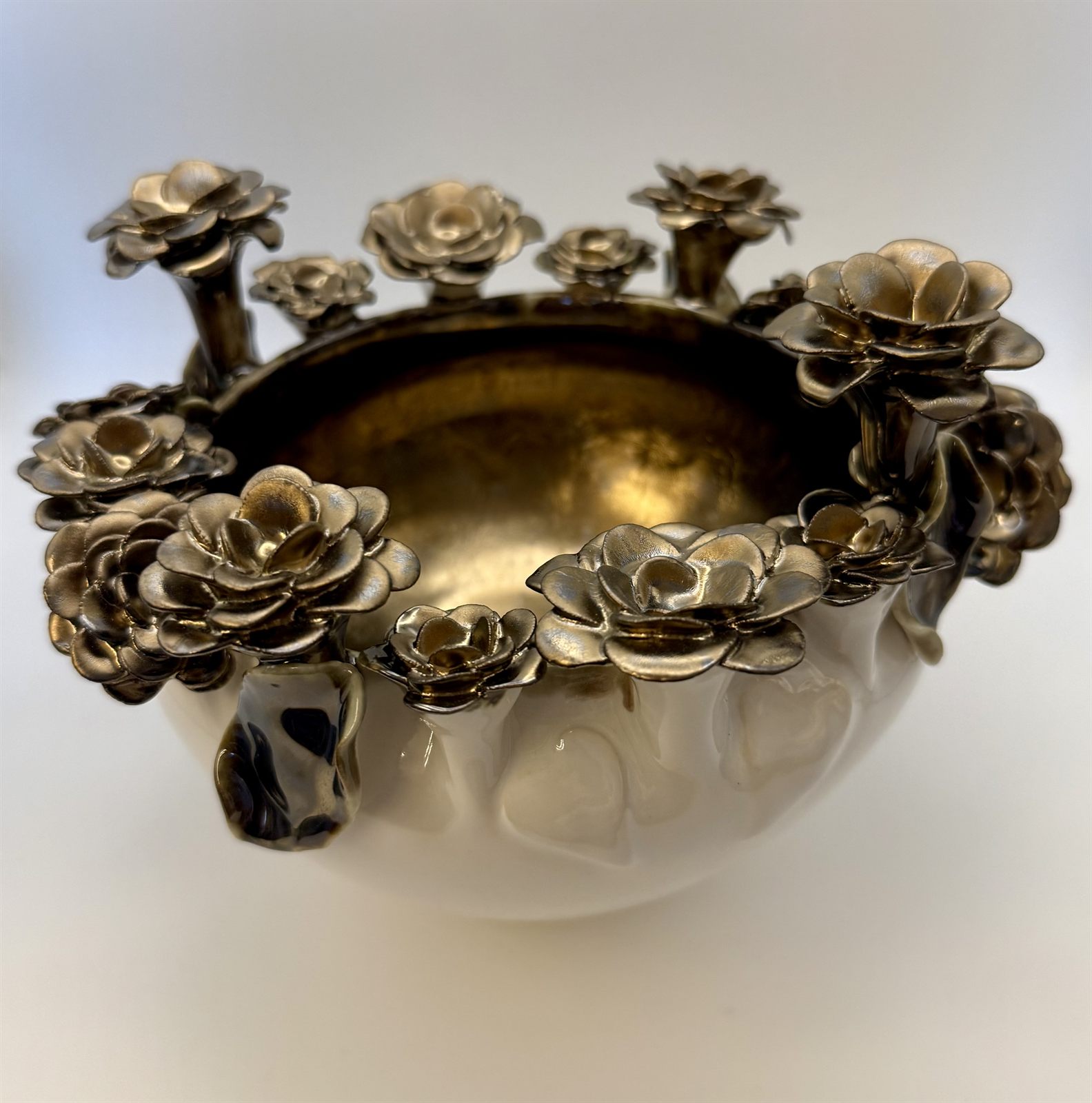 Metallic bronze-gold bowl with gilded sculpted roses crowding the rim