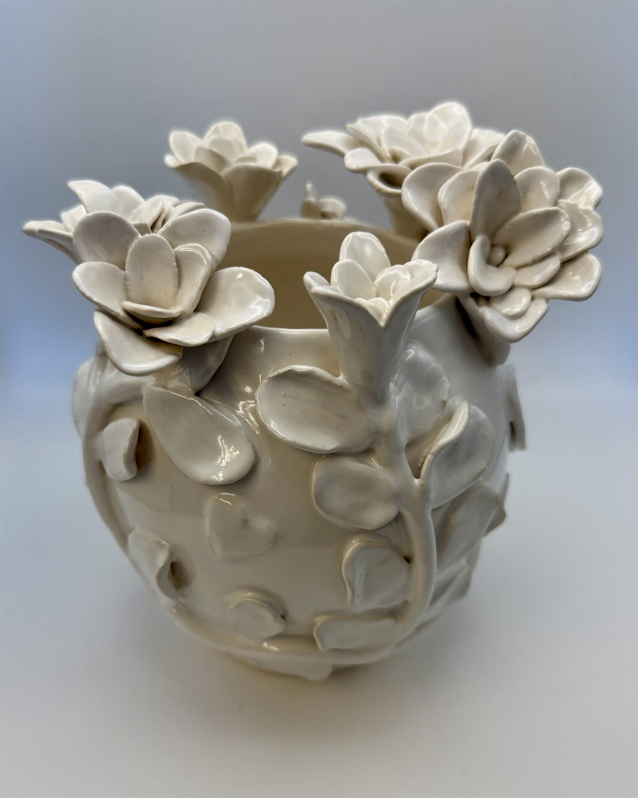 All-white vessel covered in sculpted blossoms, vines, and small hearts